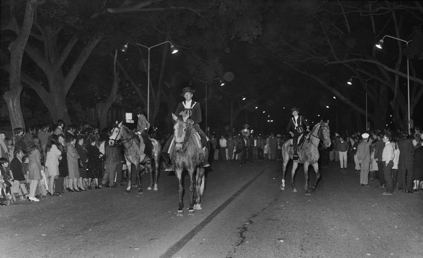 Curiosa fotografía del cortejo procesional de los Gitanos en la Alameda Principal en el año 1972. En ella aparecen miembros de la Peña Caballista ataviados con el traje corto y luciendo el escapulario de la corporación, montados en sus correspondientes equinos.