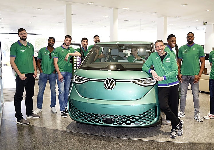 Los jugadores y técnicos del Unicaja, junto a uno de los últimos modelos de Volkswagen, en su visita este viernes a Malaga Wagen.
