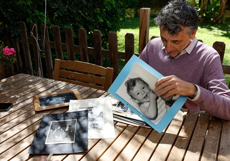 Sebastián Escámez contempla fotos en las que sale su padre y su hijo Gabriel, fallecido.