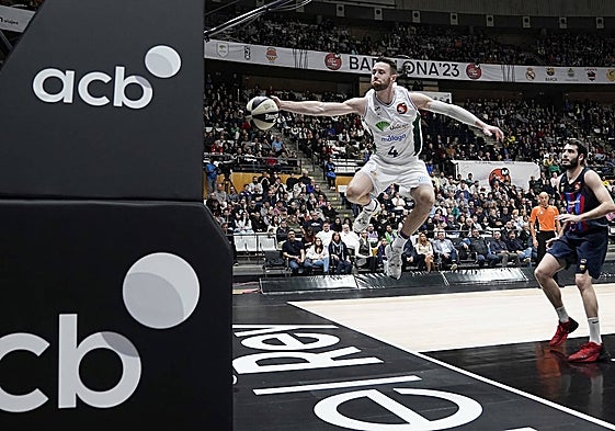 Kalinoski salta para evitar que la bola salga por la línea de fondo en presencia de Abrines, en el reciente Unicaja-Barça copero en Badalona.
