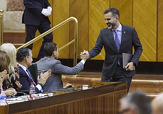 El presidente, Juanma Moreno, saluda al consejero de Sostenibilidad, Ramón Fernández-Pacheco tras la aprobación de la ley