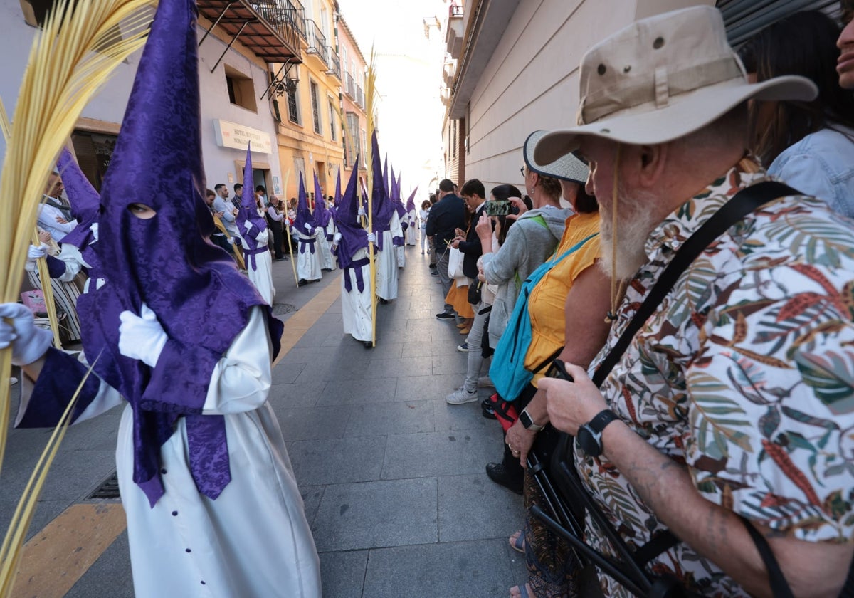 Turistas asisten a una procesión en el Centro de Málaga.