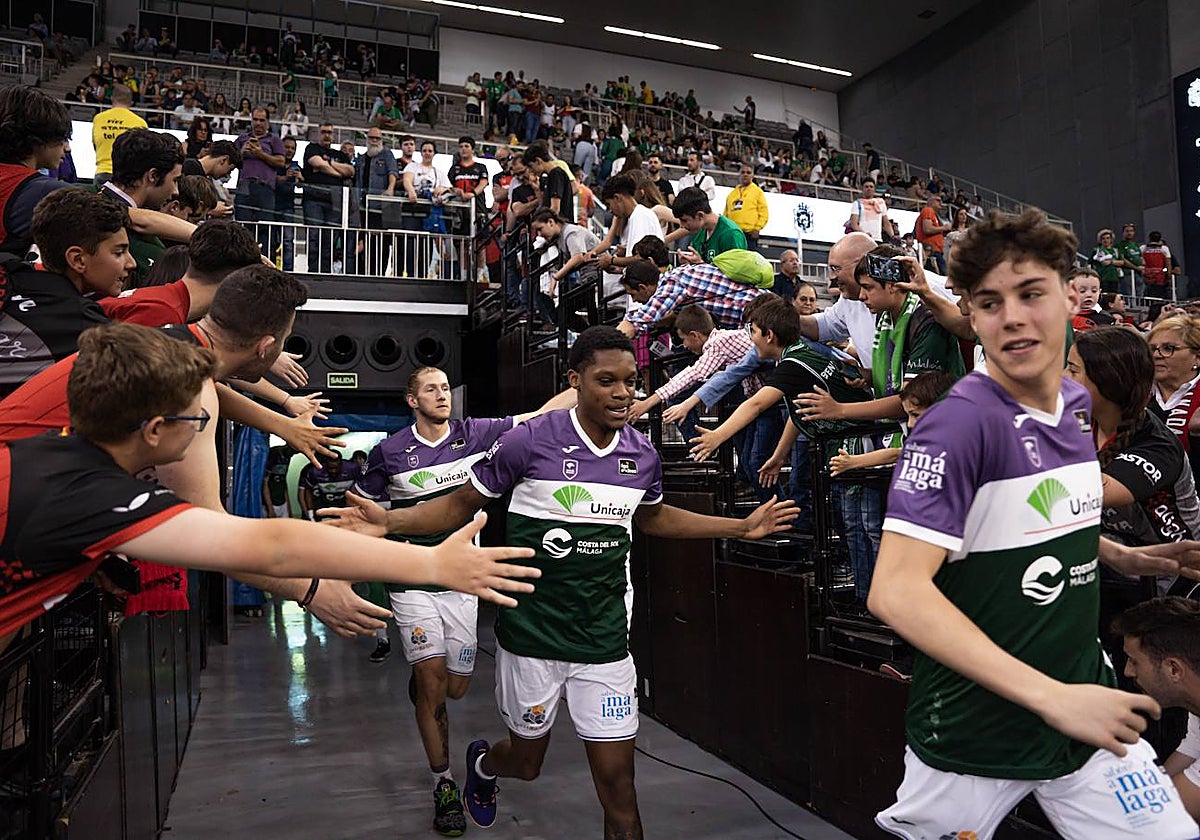 Los jugadores del Unicaja saltan a la pista del Palacio de Deportes de Granada el sábado, jaleados por aficionados.