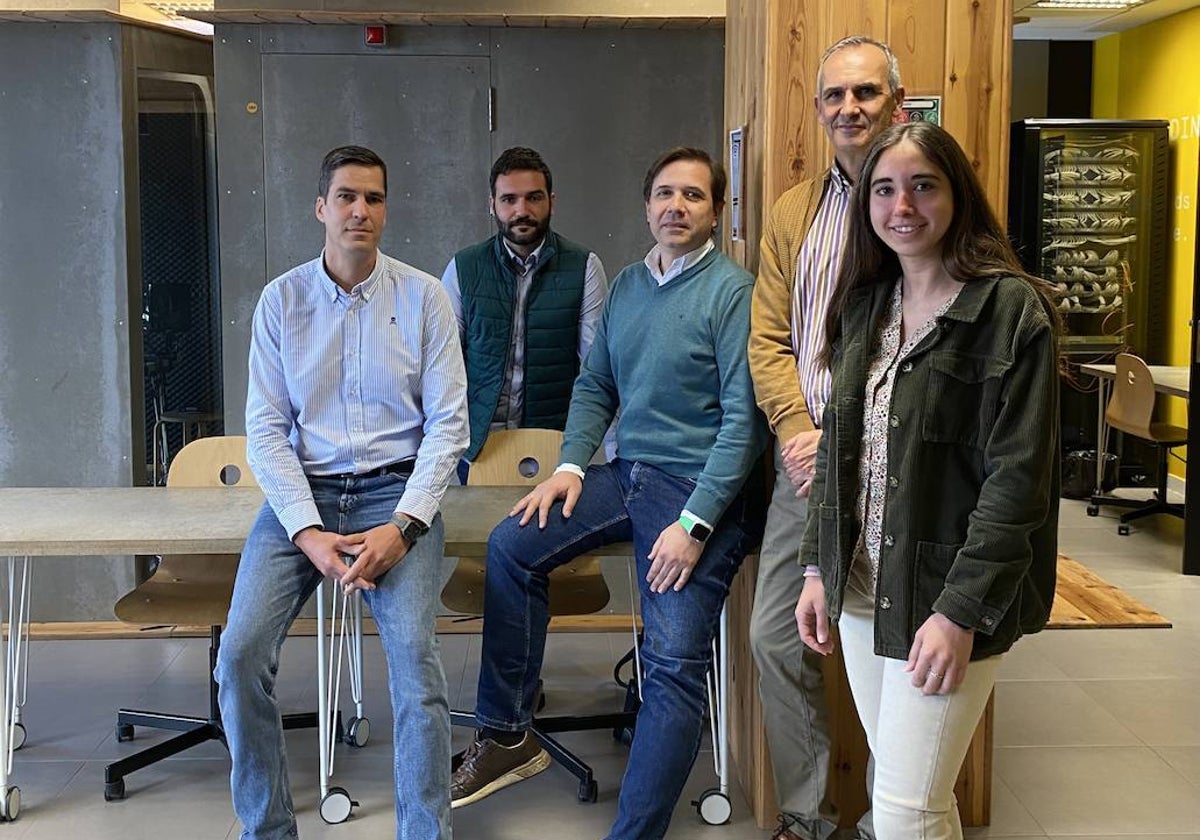 Los cuatro creadores de la empresa posan con su primera becaria en las instalaciones compartidas de la UMA.
