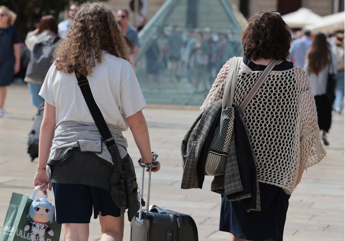 Turistas se dirigen hacia su alojamiento en la capital malagueña.