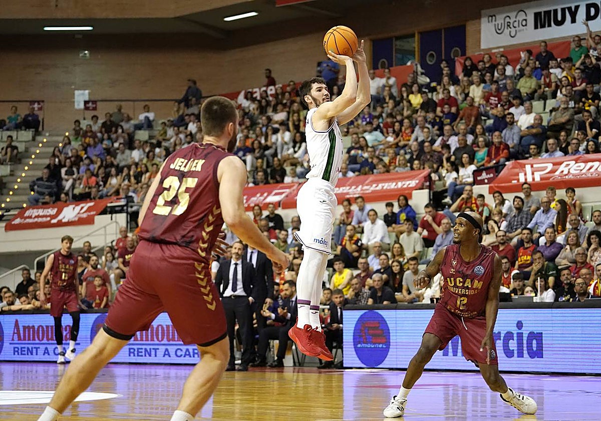 Brizuela se eleva ante la mirada de McFadden para anotar una canasta.