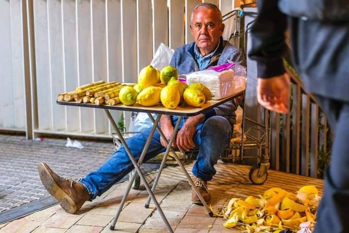 Un hombre vende limones 'cascaruos' con sal por las calles de Málaga en Semana Santa. 