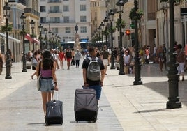 Turistas se dirigen a su alojamiento por el Centro de la ciudad.