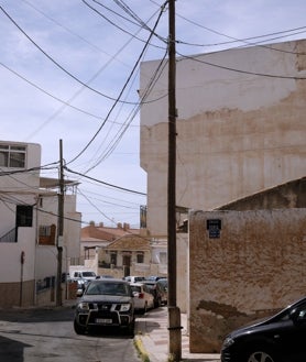 Imagen secundaria 2 - Los cables también cuelgan de las fachadas de las viviendas, mientras los postes bloquean el paso a los viandantes.