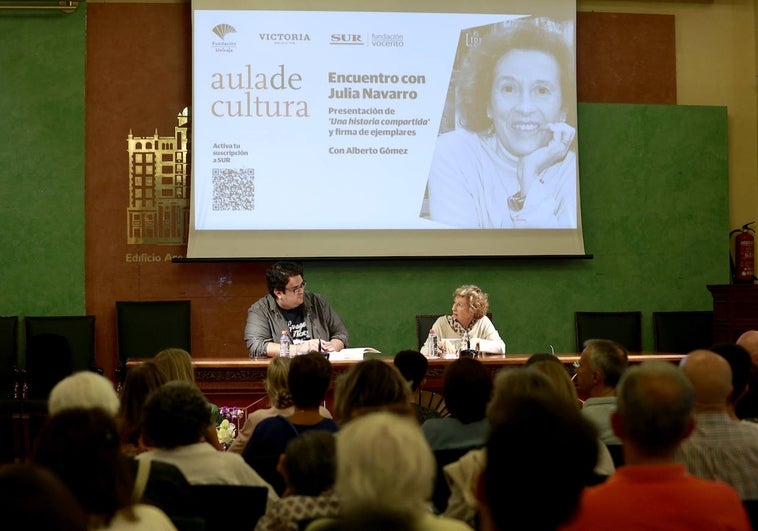 El codirector del Aula de Cultura Alberto Gómez, junto a la escritora Julia Navarro, este miércoles en el salón de actos de Unicaja.