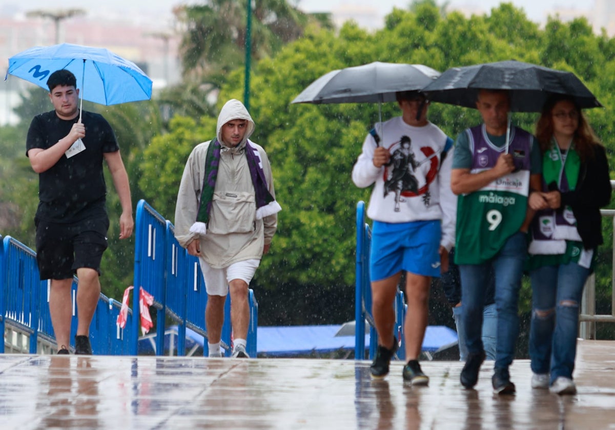 Aficionados al Unicaja, ayer de camino al partido bajo la lluvia.