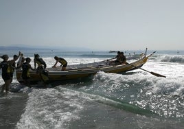 Una de las embarcaciones trata de adentrarse en el mar en contra del oleaje.