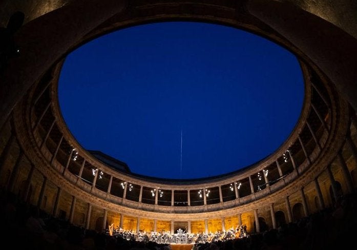 El cielo azul del Palacio de Carlos V, testigo de una noche de éxito para cantantes y orquesta.