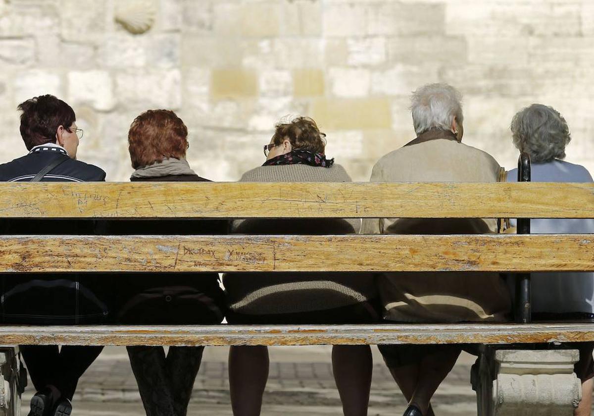 Un grupo de personas mayores sentadas en un banco.