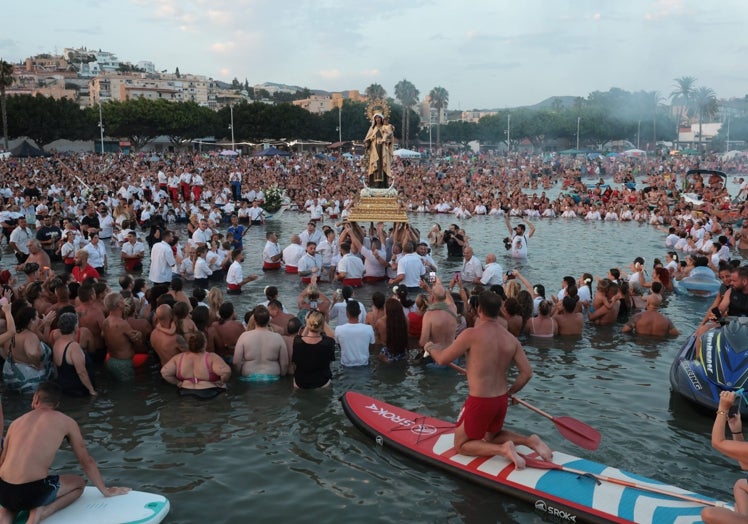 la Virgen de El Palo portada a pulso dentro del mar.