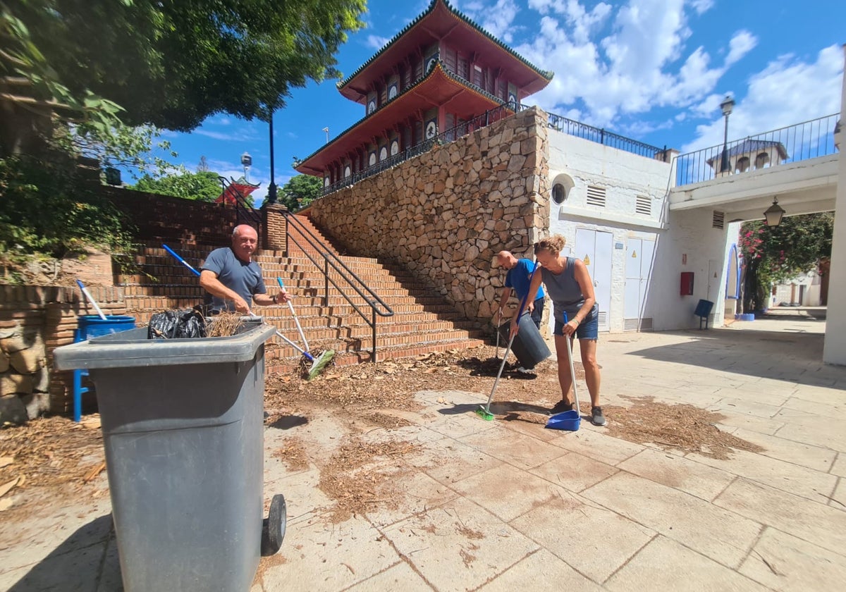 Trabajadores del parque limpian las hojas que han caído de los árboles.