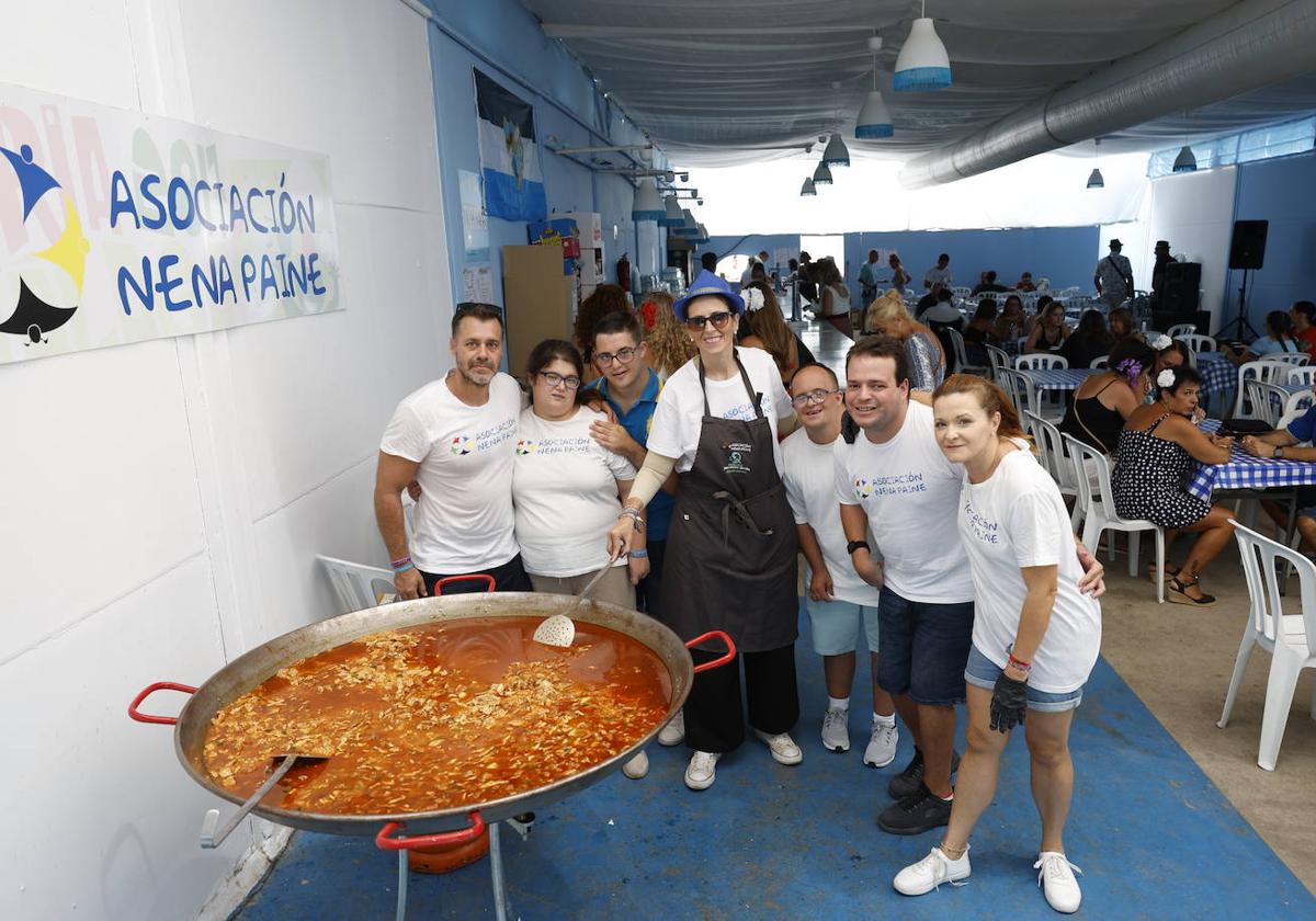 Mercedes García Paine, en el centro, junto con los 'Supercurrantes', en la caseta de su asociación en la feria del real, este viernes.