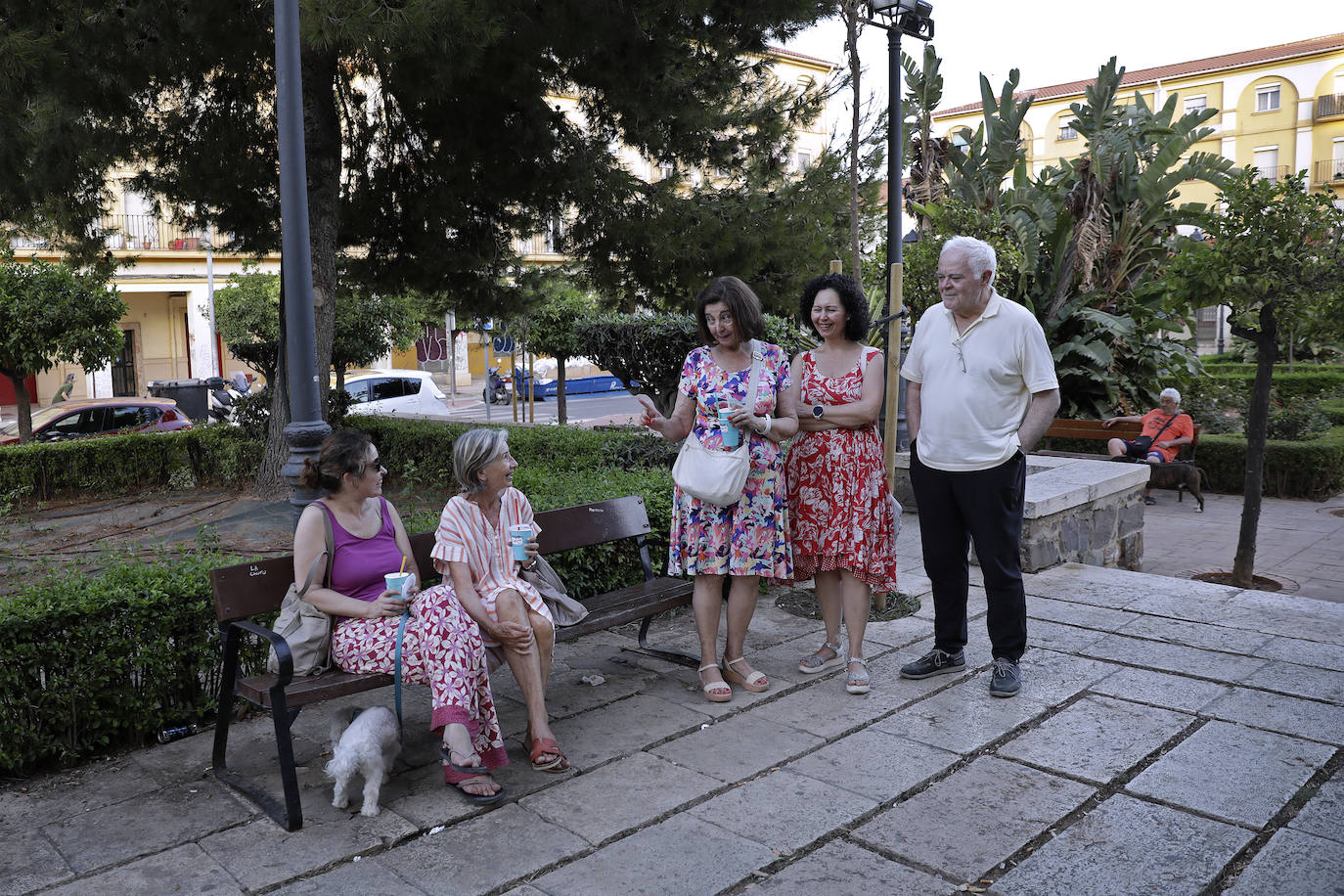 Un grupo de ciudadanos conversa sobre la situación del barrio de Carranque, el más envejecido de Málaga, en la plaza de Pío XII.