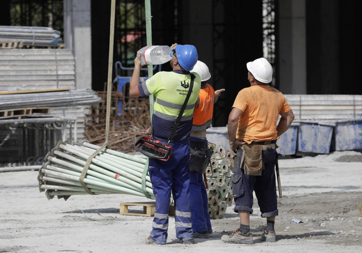 Trabajadores de la construcción refrescándose este verano en Málaga.