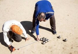 Dos hombres juegan a la petanca.