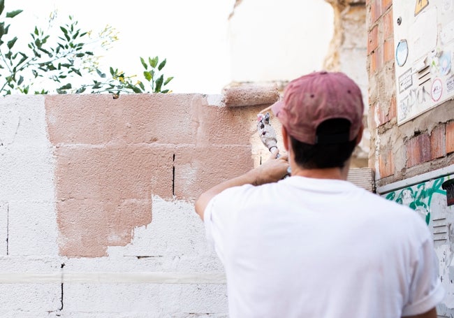 Dreucol pintando un muro.