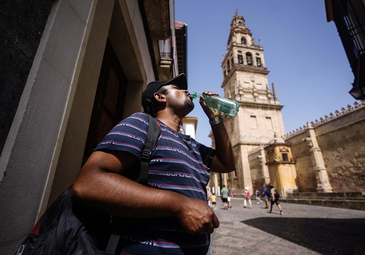 Un turista se refresca en una calle de la Judería de Córdoba durante una ola de calor que puso en aviso rojo al Valle del Guadalquivir el verano del año pasado.