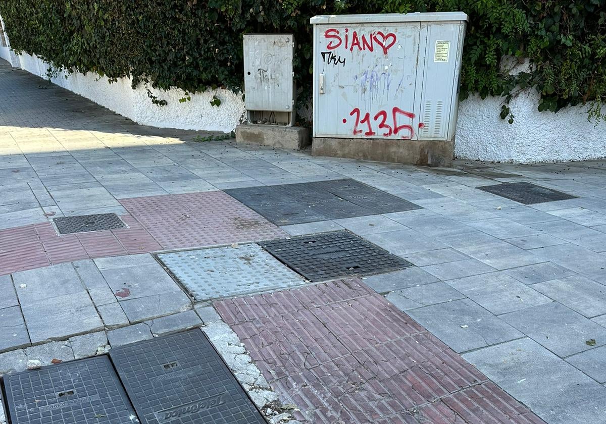 Vista de la acera del Paseo de las Acacias, al fondo, el cajetín de la luz en mal estado.