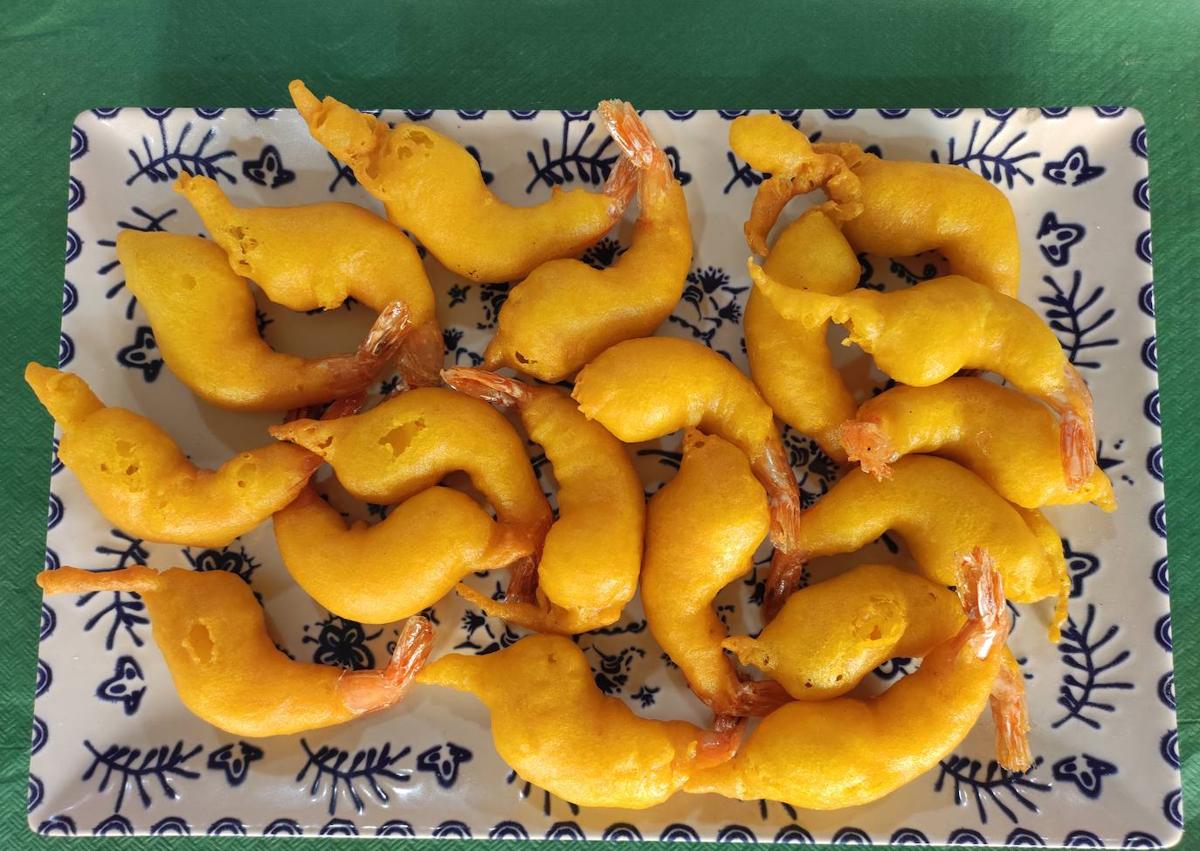 Imagen secundaria 1 - Antonio Díaz y Alejandro Zabou, con platos emblemáticos de la freiduría La Cueva. Abajo, gambas rebozadas y ensalada de pescado, uno de los platos más longevos de la carta.
