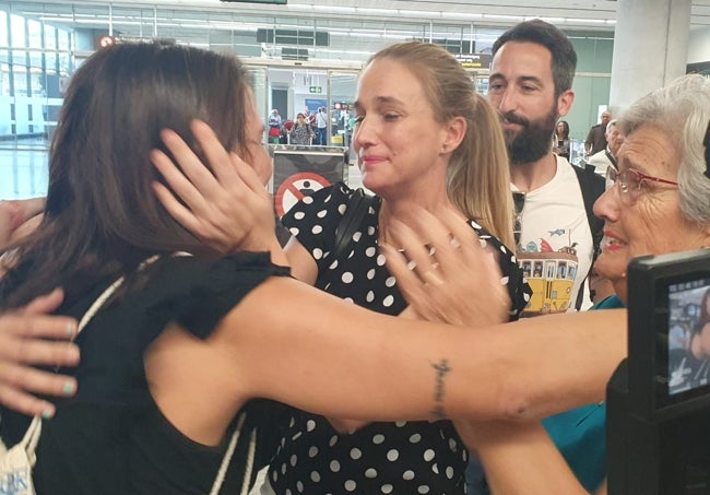 Cristina, de espaldas, abraza a su hermana Verónica, con Fran detrás, y Ana, la madre de Cristina, en el aeropuerto de Málaga, esta tarde.