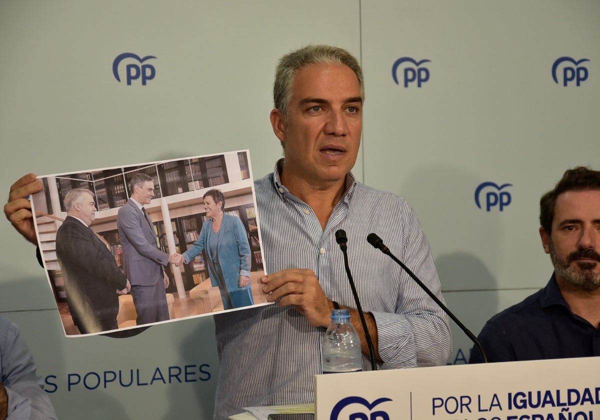 Elías Bendodo sostiene una imagen del encuentro entre Sánchez y Aizpurua, en un acto del PP en Antequera.