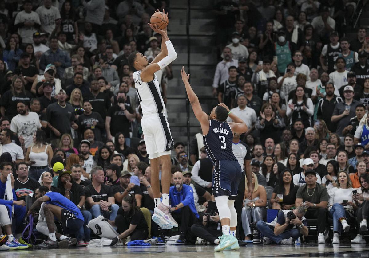 Wembanyama realiza un lanzamiento cómodo en su debut ante Dallas. Su defensor en la foto, Grant Williams, mide 1,98