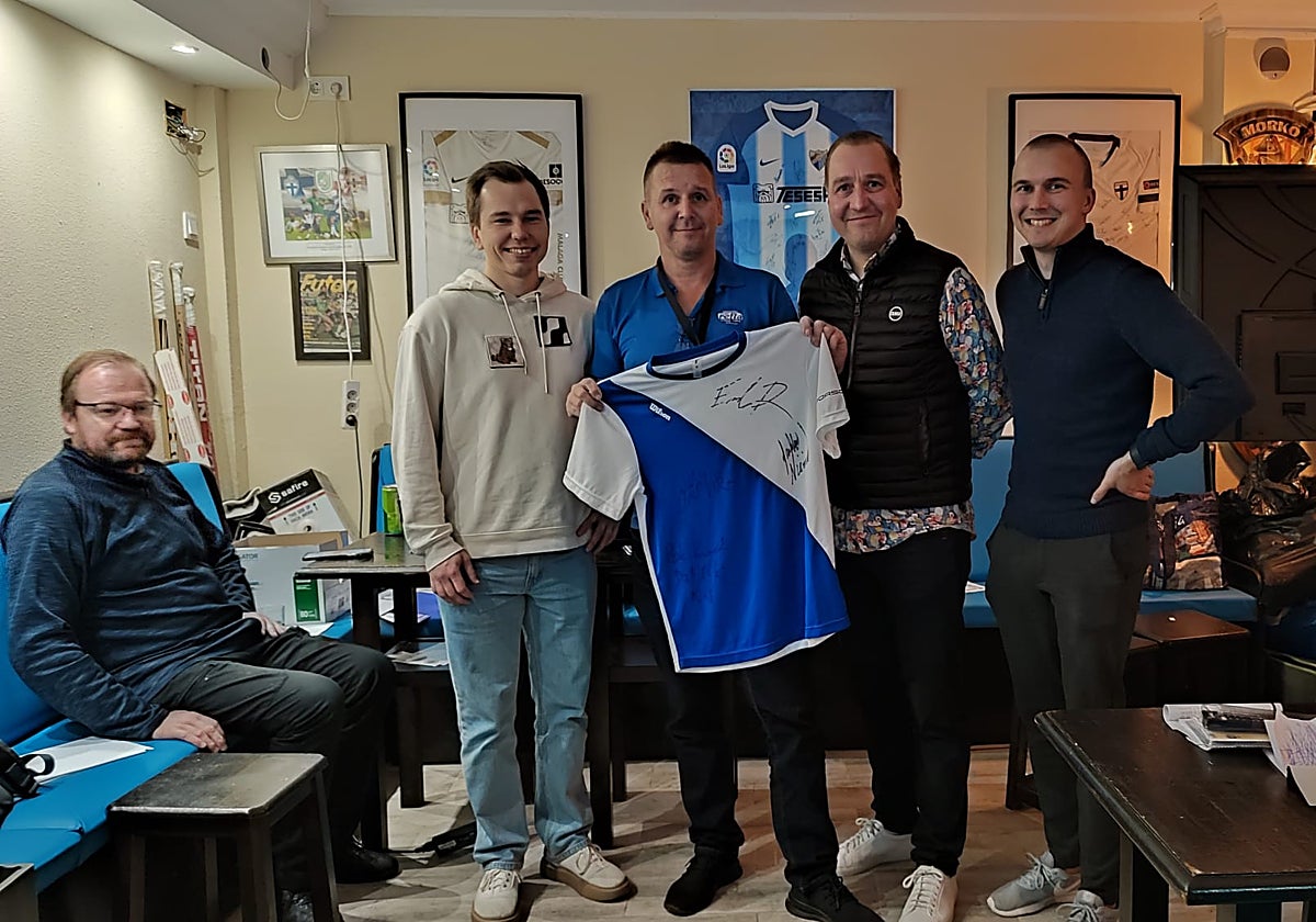 Tenistas aficionados fineses de Fuengirola muestran una camiseta firmada por los componentes del conjunto de Copa Davis de su país.