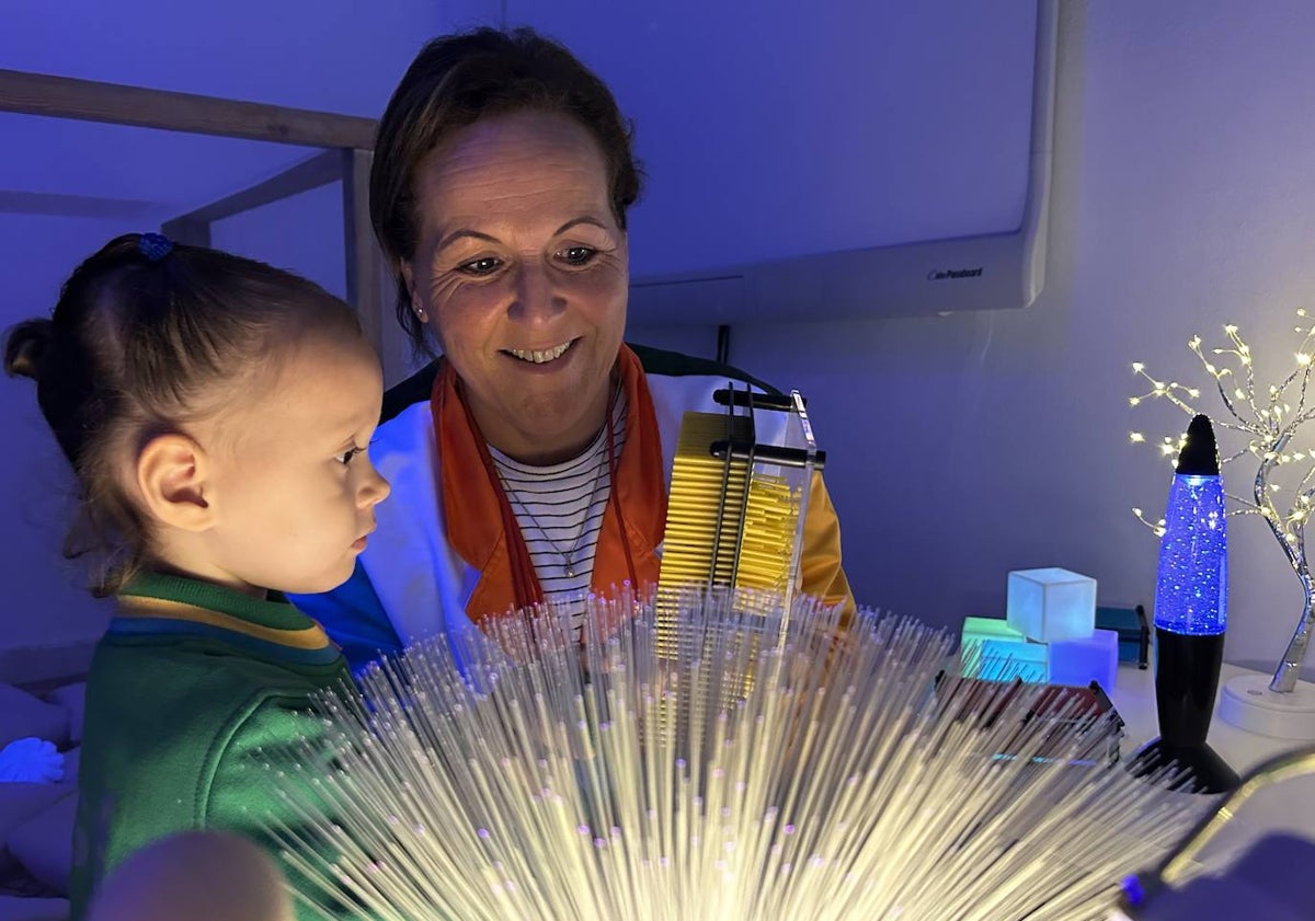 Imagen principal - La maestra Almudena Rivas, junto a una alumna; una alumna observa las columnas de burbujas y un alumno enseña unas gafas fluorescentes.