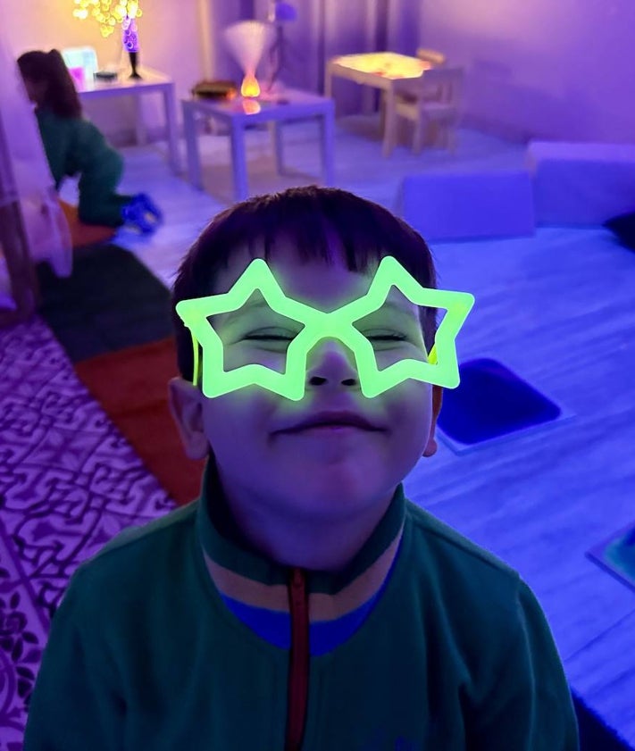 Imagen secundaria 2 - La maestra Almudena Rivas, junto a una alumna; una alumna observa las columnas de burbujas y un alumno enseña unas gafas fluorescentes.