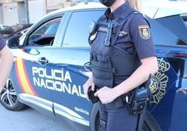 Imagen de archivo en la que aparece una agente de la Policía Nacional junto al vehículo policial.