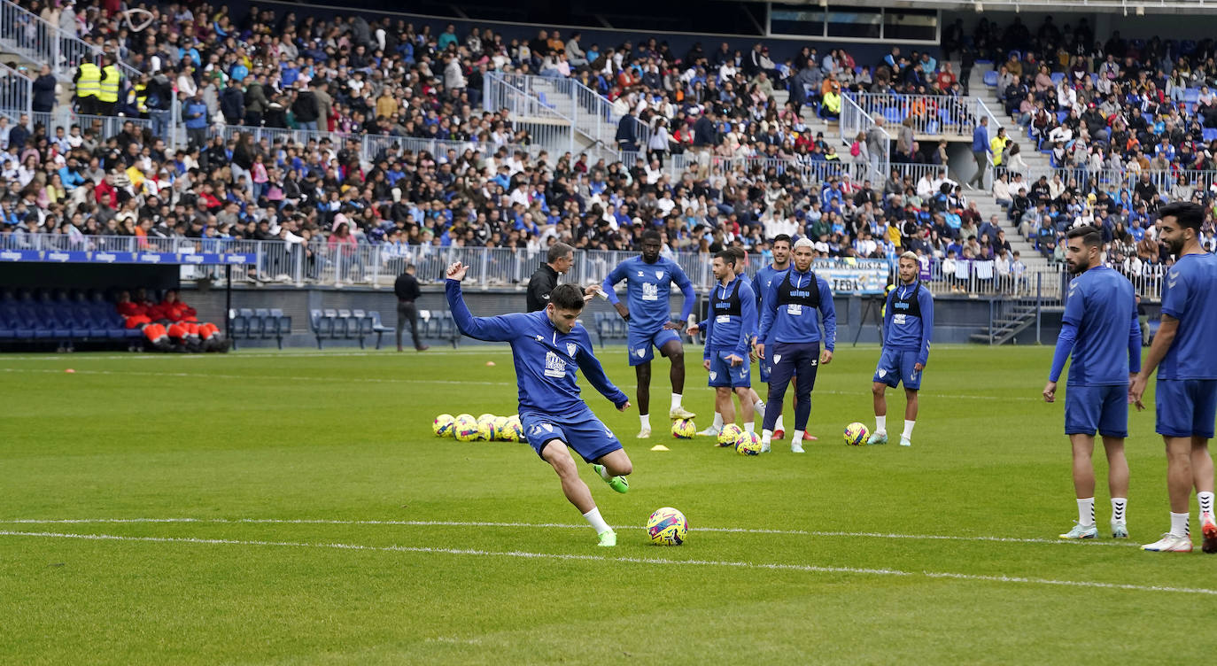 Miles de seguidores, entre ellos muchos niños, acuden en masa a La Rosaleda para ver una sesión de trabajo del equipo blanquiazul en la víspera del Día de Reyes. 