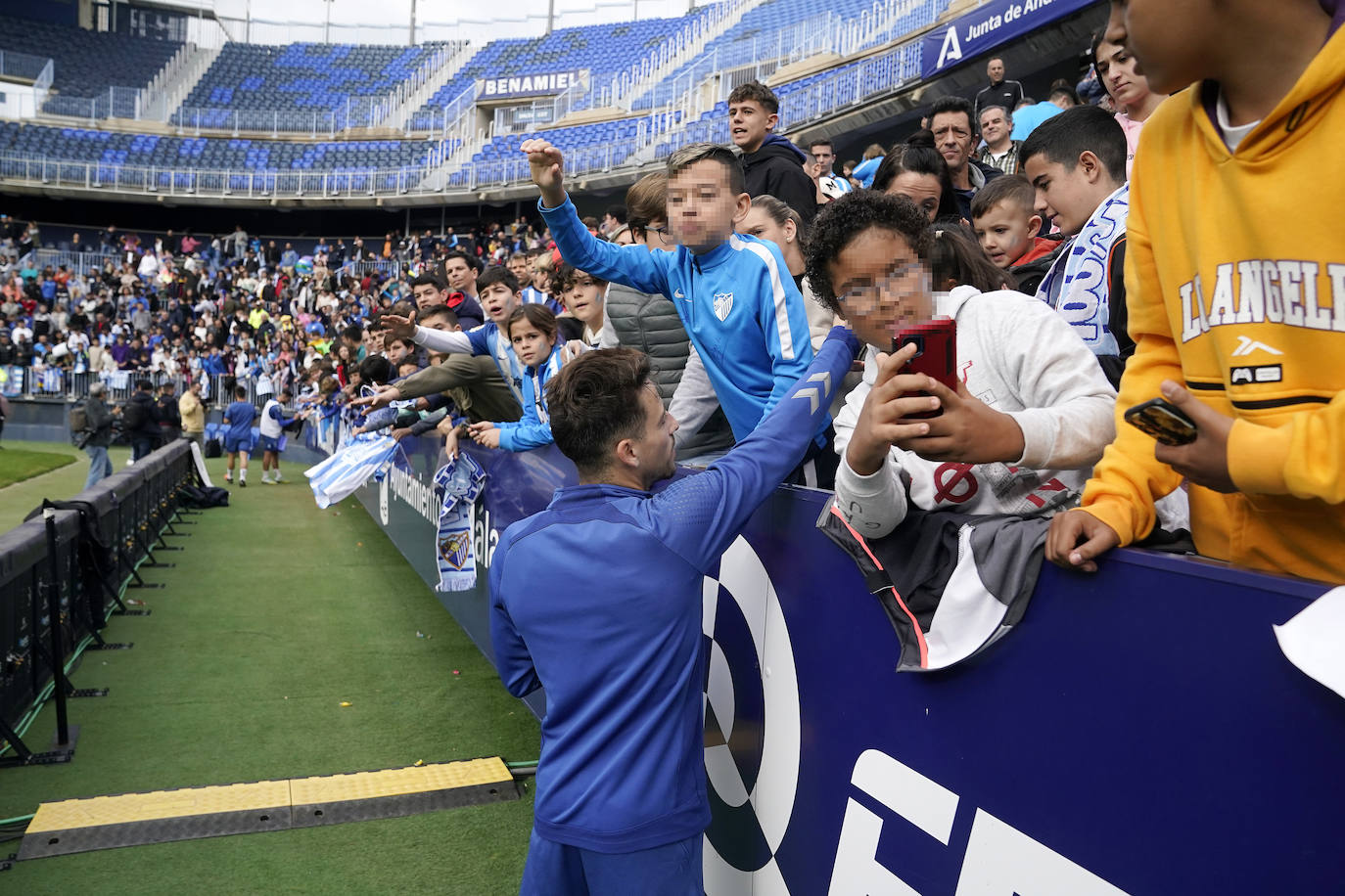 Miles de seguidores, entre ellos muchos niños, acuden en masa a La Rosaleda para ver una sesión de trabajo del equipo blanquiazul en la víspera del Día de Reyes. 