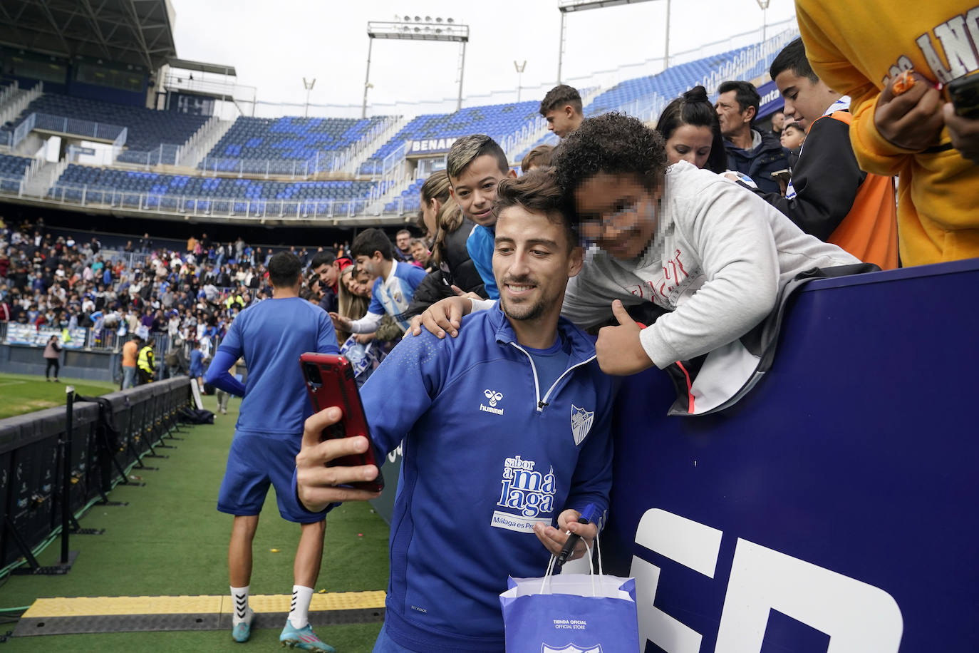 Miles de seguidores, entre ellos muchos niños, acuden en masa a La Rosaleda para ver una sesión de trabajo del equipo blanquiazul en la víspera del Día de Reyes. 