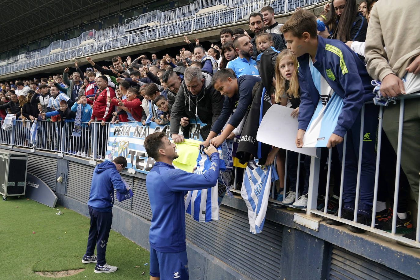 Miles de seguidores, entre ellos muchos niños, acuden en masa a La Rosaleda para ver una sesión de trabajo del equipo blanquiazul en la víspera del Día de Reyes. 