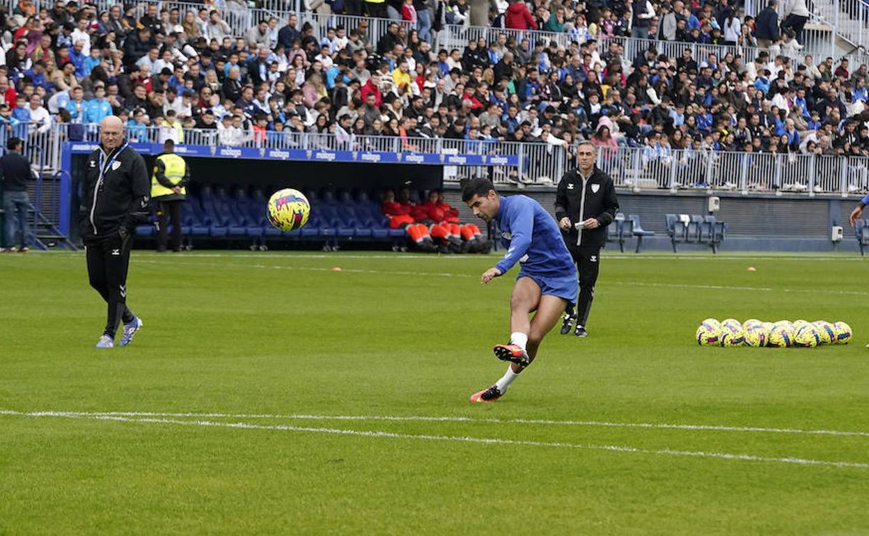 Juanfran dispara a portería en el entrenamiento de este jueves en La Rosaleda ante la mirada del entrenador Pepe Mel.