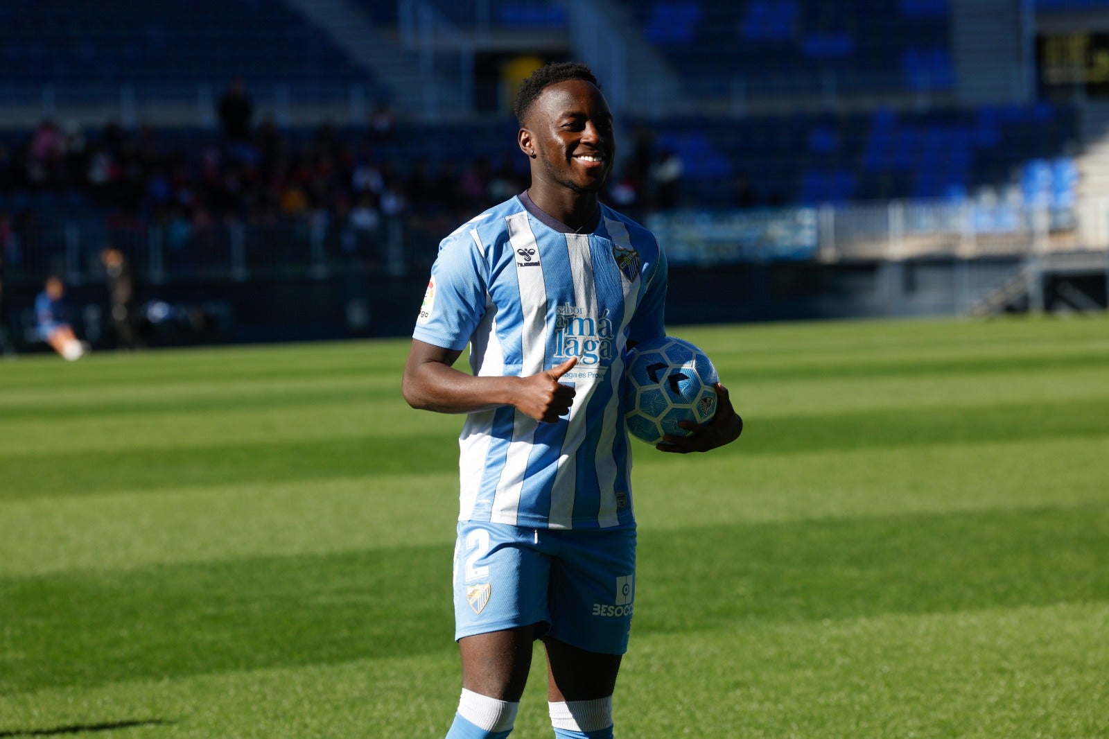 Appiah, con el pulgar hacia arriba ante los medios gráficos desde el césped de La Rosaleda. Ha elegido el dorsal '2'. 