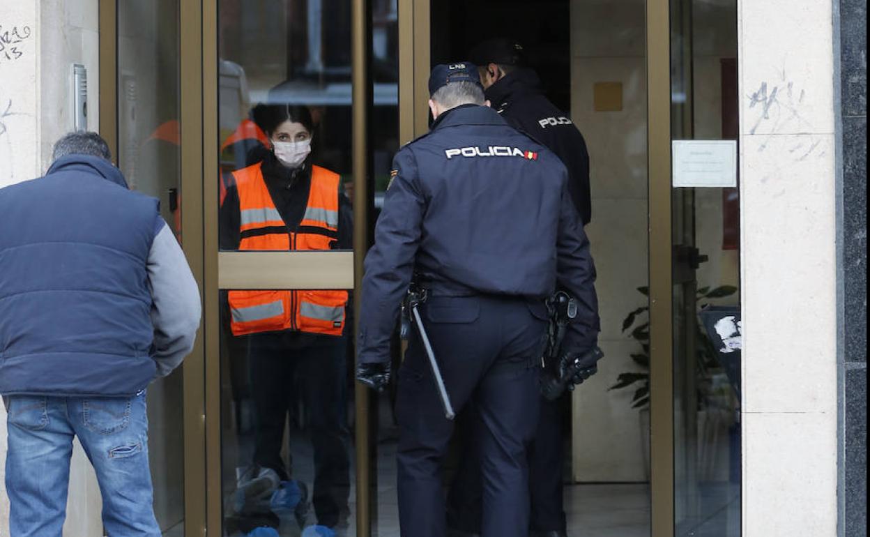 Policías y trabajadores de la funeraria entran el lunes en el portal de la vivienda vallisoletana donde asesinaron a la madre y a la hija.