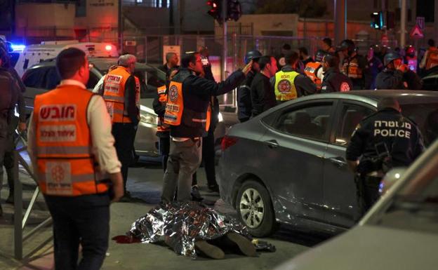 Los servicios de emergencia cubren el cuerpo de una víctima tras el ataque a una sinagoga. 