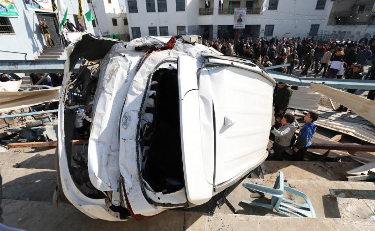 Palestinos observan un vehículo destrozado a causa de una incursión militar del Ejército israelí en el campo de refugiados de Yenín, el jueves.