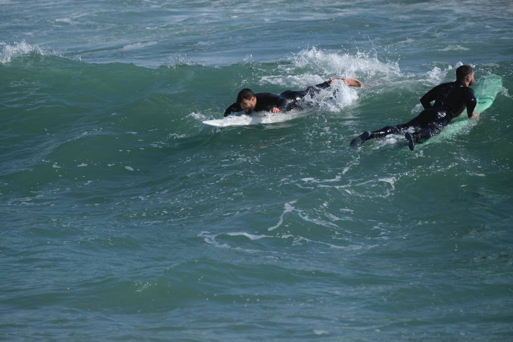 Tablas y ganas de coger olas en la playa de Huelin, este domingo. Surfistas aprovechan el viento de levante y la olas del temporal para meterse en el agua en distintos puntos de Málaga