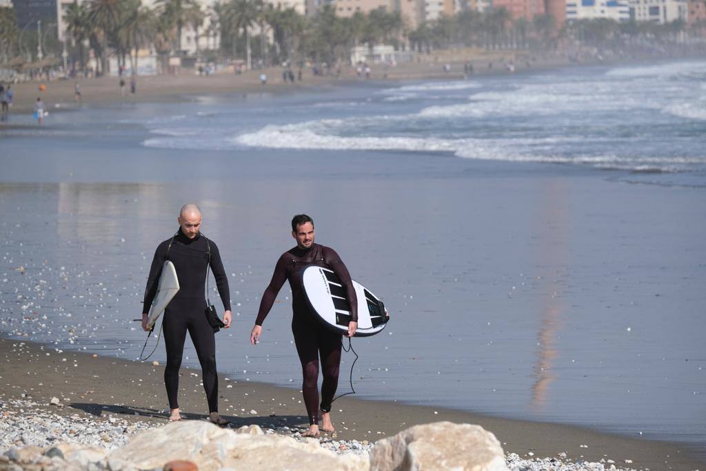 Tablas y ganas de coger olas en la playa de Huelin, este domingo. Surfistas aprovechan el viento de levante y la olas del temporal para meterse en el agua en distintos puntos de Málaga