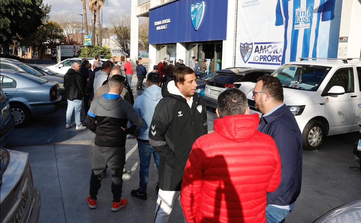 Aficionados hacen cola este lunes a las puertas de la tienda-taquilla del Málaga. 