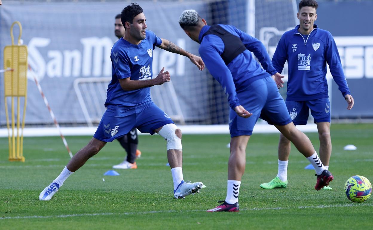 El jugador del Málaga, Alberto Escassi, se ejercita con una protección en su rodilla izquierda.