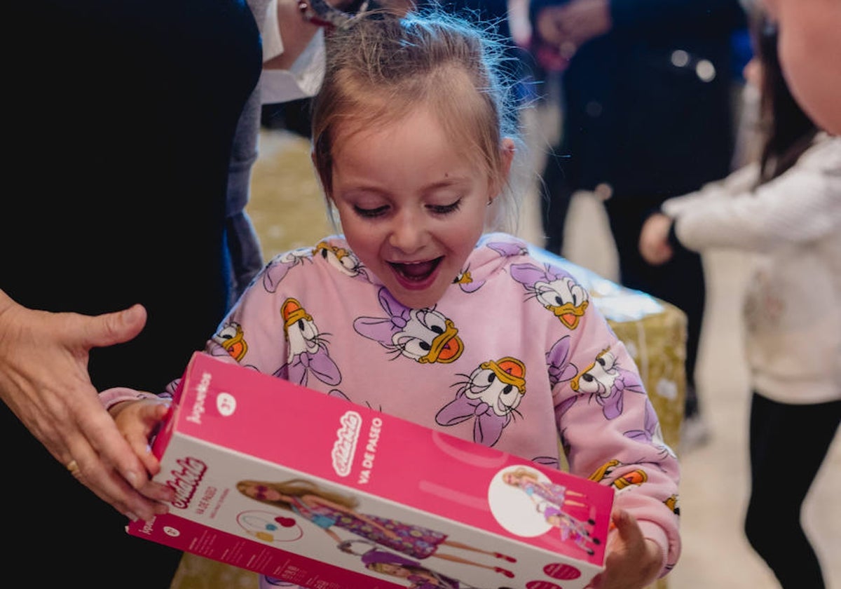 Una de las niñas, al abrir su regalo.