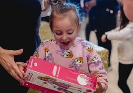Una de las niñas, al abrir su regalo.